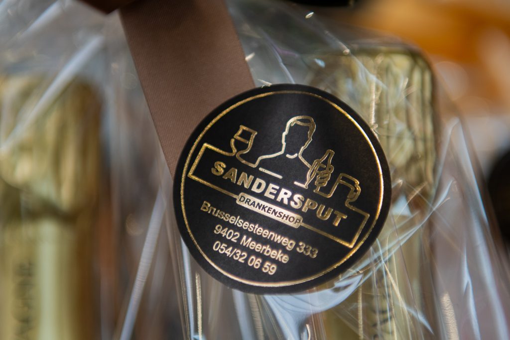 Gepersonaliseerde Sandersput-sticker op een drankgeschenk van de drankenshop in Ninove.