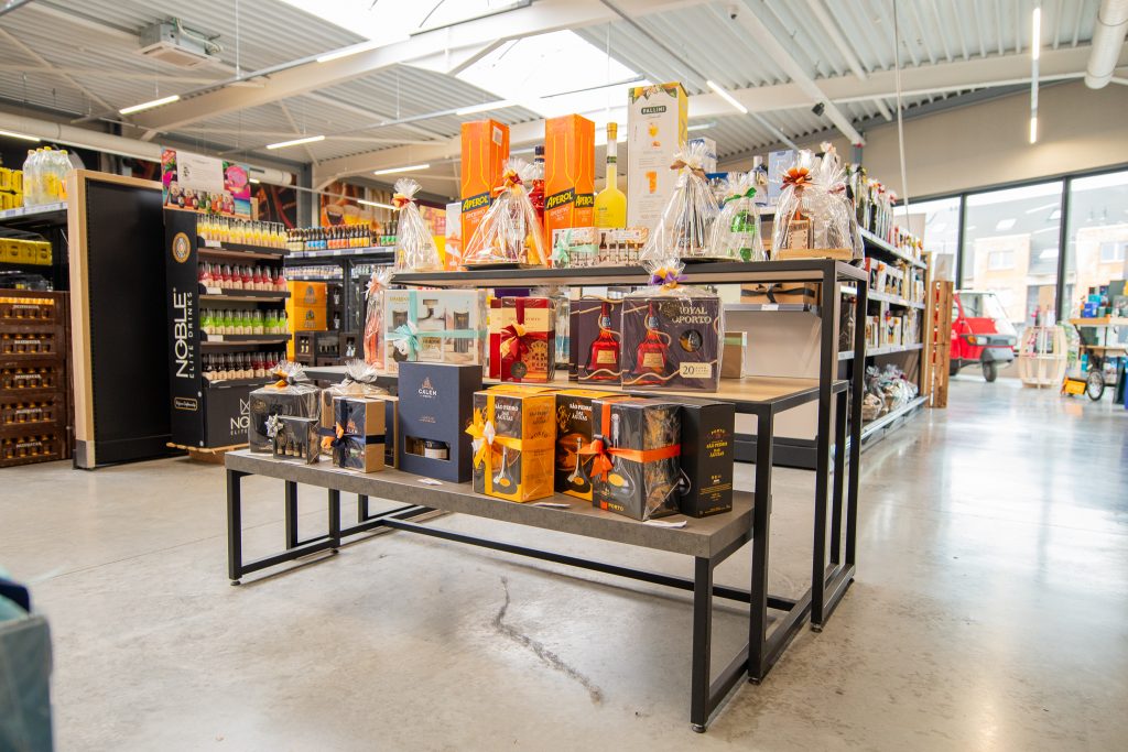 Uitgebreid aanbod van drankgeschenken en geschenkpakketten met porto en aperitieven in een winkel van Dranken Vandenameele.