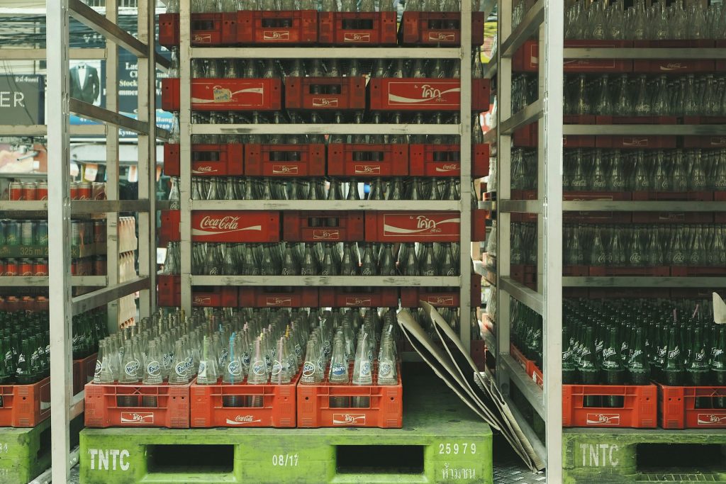 Nette rijen lege glazen flessen in Coca-Cola kratten, klaar voor retour en hergebruik.