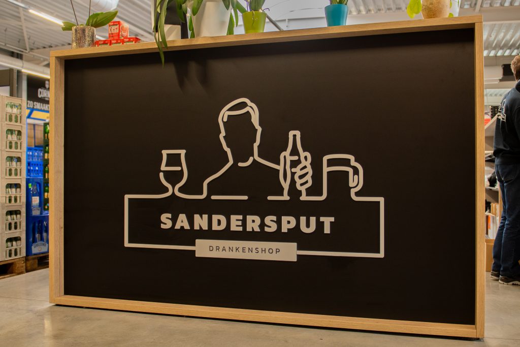 Logobord van Drankenshop Sandersput, één van de winkels van Dranken Vandenameele.
