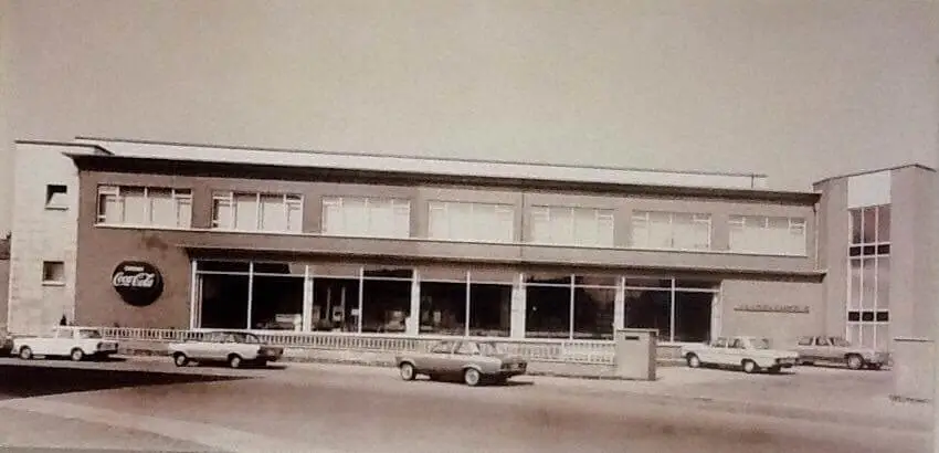 Historische zwart-witfoto van het bedrijfsgebouw van Vandenameele aan de 1 Meistraat in Aalst met Coca-Cola logo.